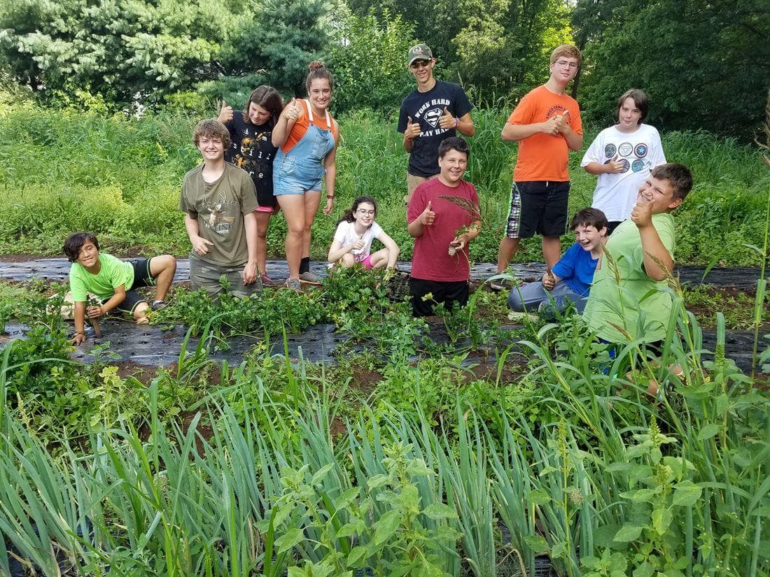 Group of kids in garden giving thumbs up